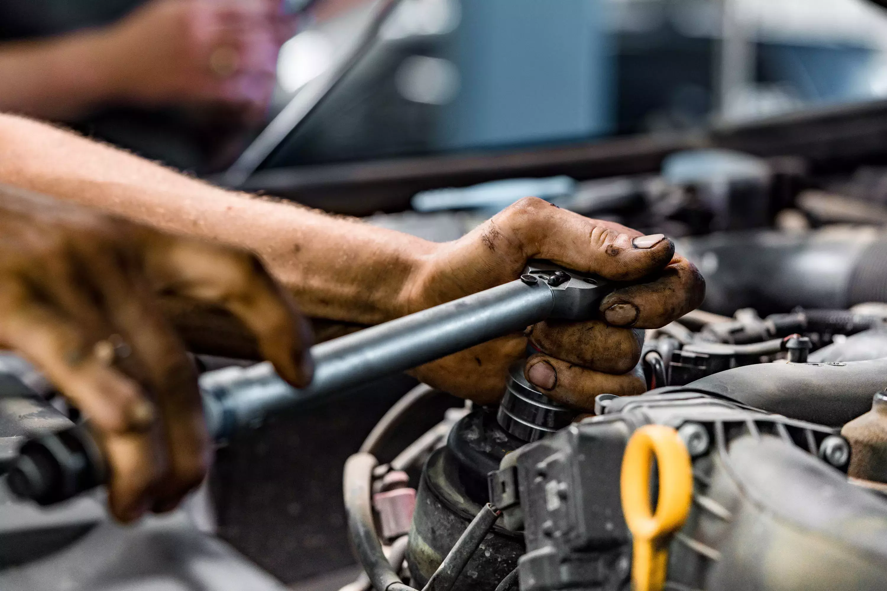 Close up of auto mechanic repairing car engine in car service.