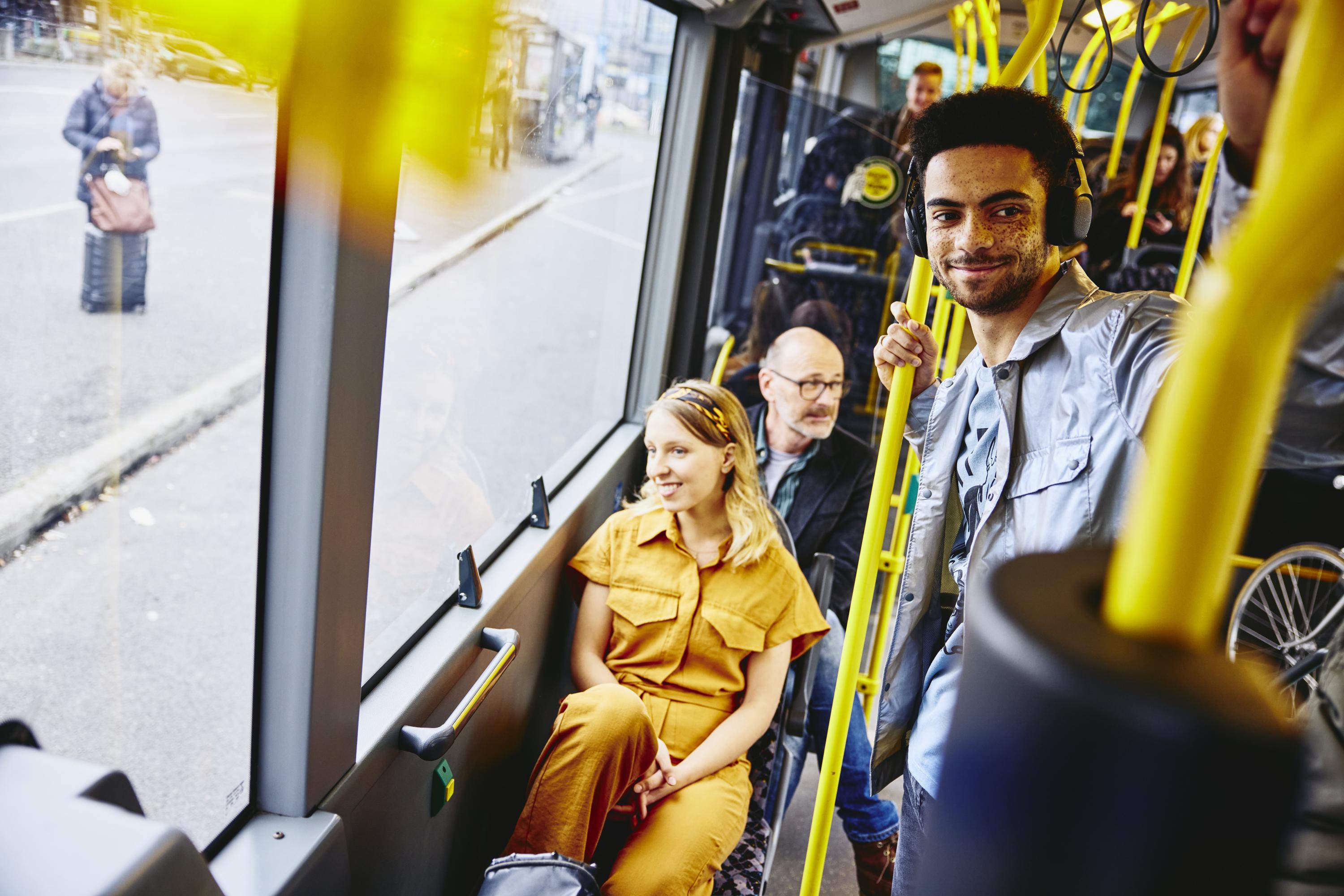 Smiling people looking outside from the bus.