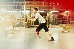 A man with a prosthetic leg pushing some boxes