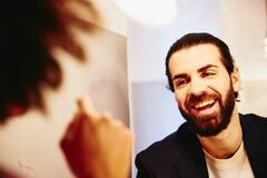 an image of a bearded man smiling at his coworker