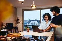 man and woman smiling looking at the computer