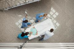 Nurses and doctors escorting a patient on a stretcher