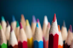 image showing a bundle of different coloured colouring pencils, with one red pencil at the forefront of the image