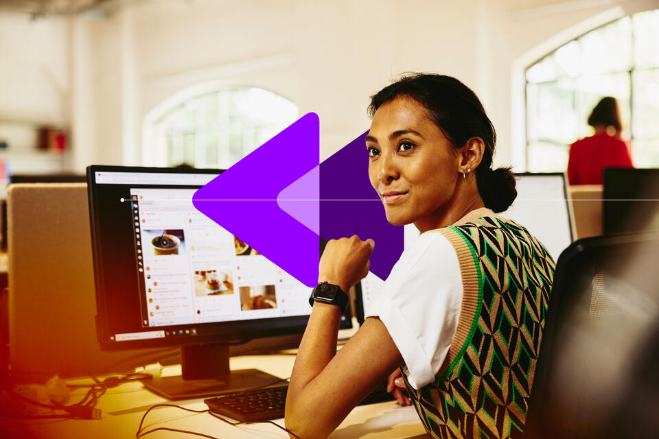 an image of a woman sitting at her desk, looking away from computer screens displaying marketing content an image of a woman sitting at her desk, looking away from computer screens displaying marketing content